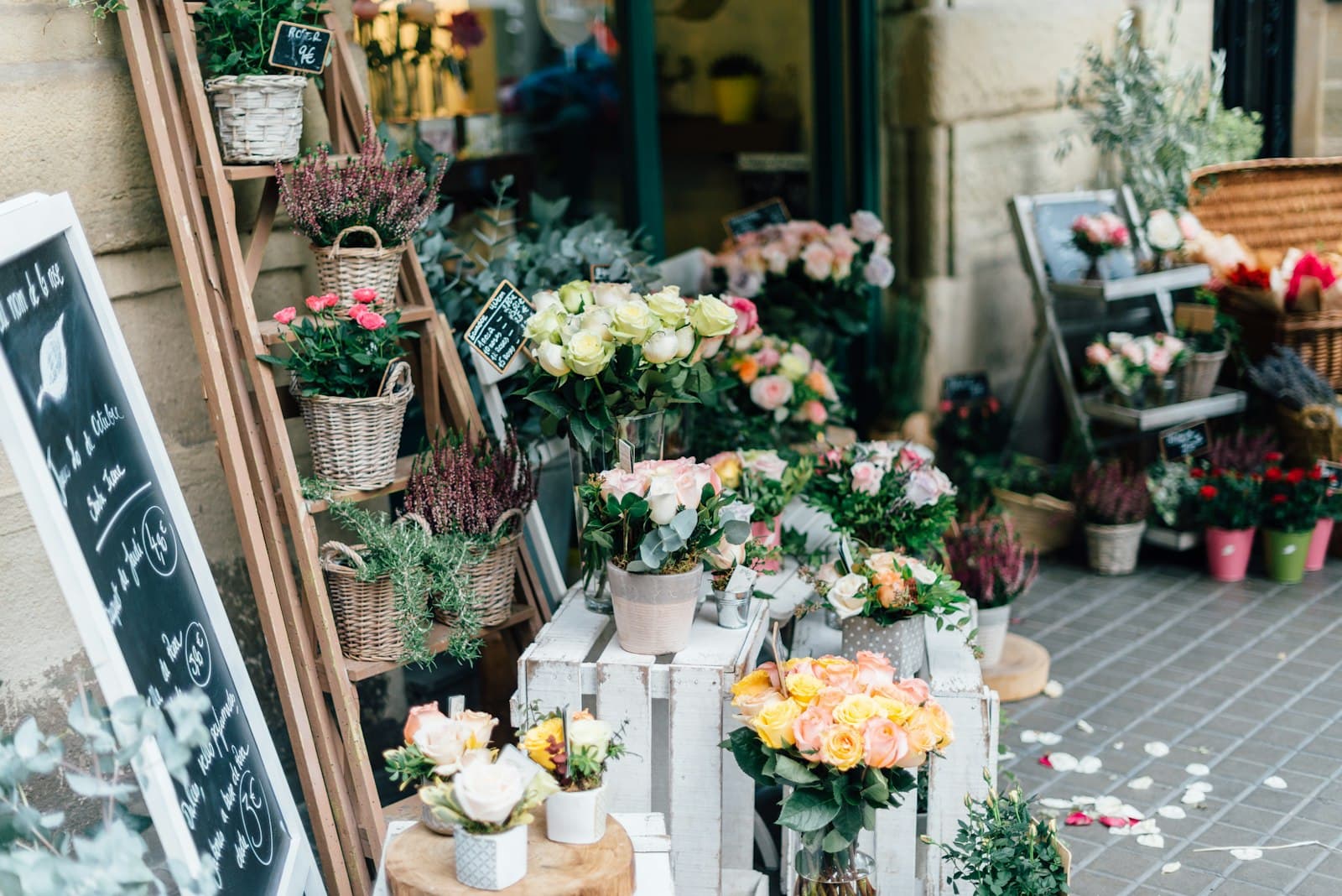 A flower shop front overflowing with fresh bouquets in buckets