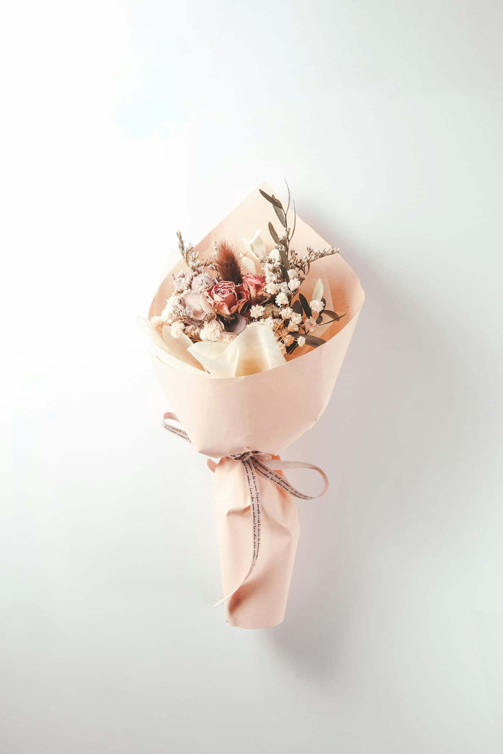 Dried flower bouquet in peach paper with a ribbon