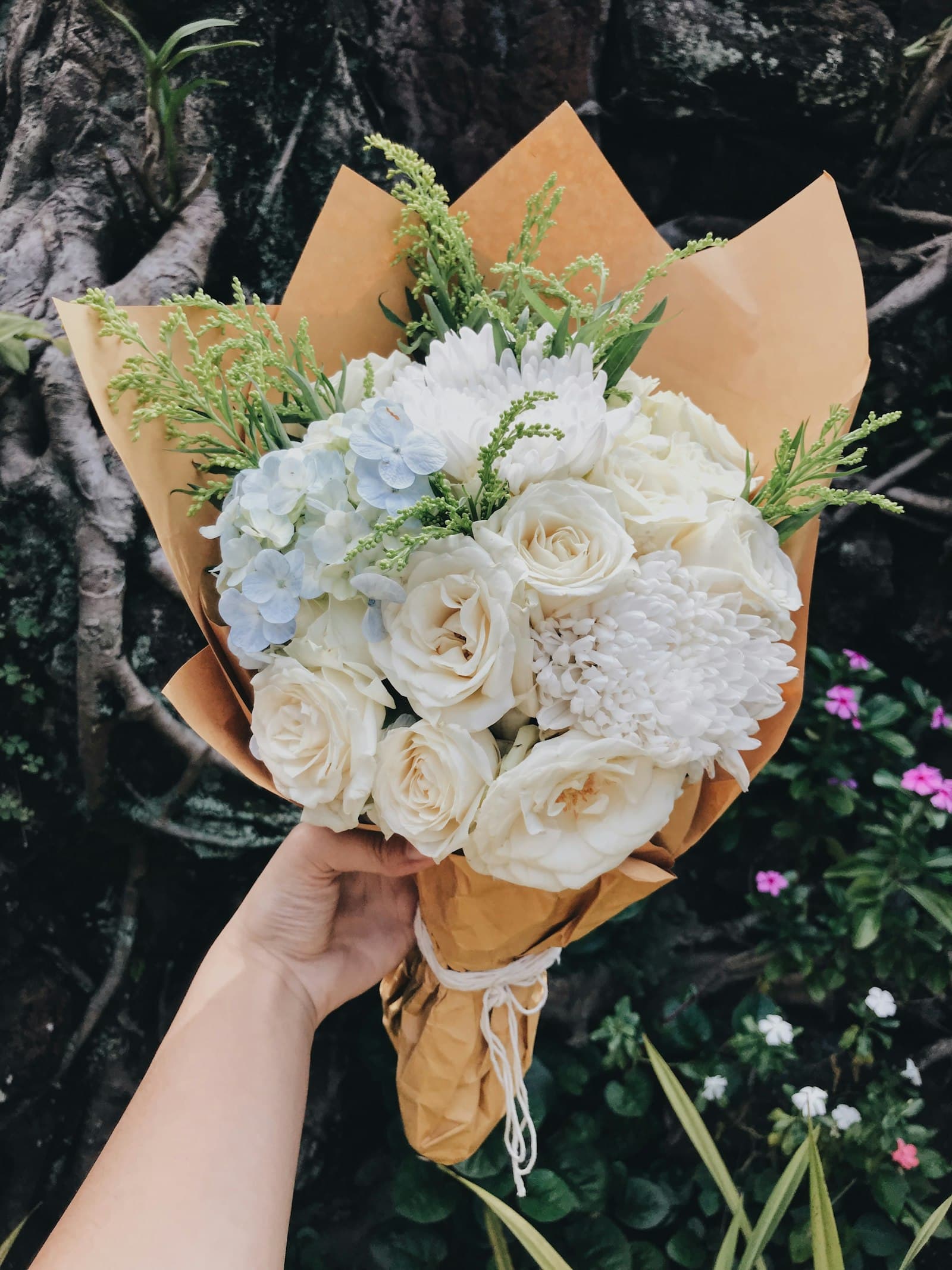 White roses, hydrangea and greenery wrapped in kraft paper